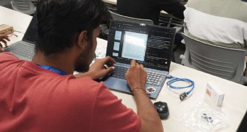 A builder working on a laptop with a hardware kit