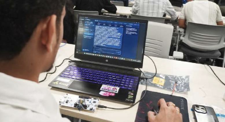 Close-up of a participant coding with hardware on the desk